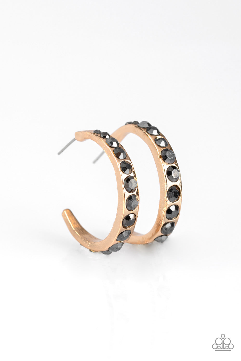 Gradually increasing in size near the center, glassy hematite rhinestones are encrusted down the spine of a dainty gold hoop for a grunge-glamorous look. Earring attaches to a standard post fitting. Hoop measures approximately 1 1/4" in diameter. Sold as one pair of hoop earrings.