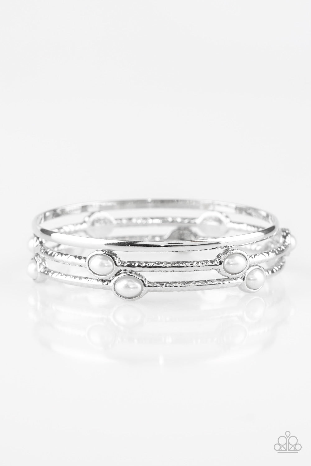 Delicately hammered in shimmer, a pair of pearly white encrusted bangles joins a smooth silver bangle around the wrist for a refined fashion. Sold as one set of three bracelets.