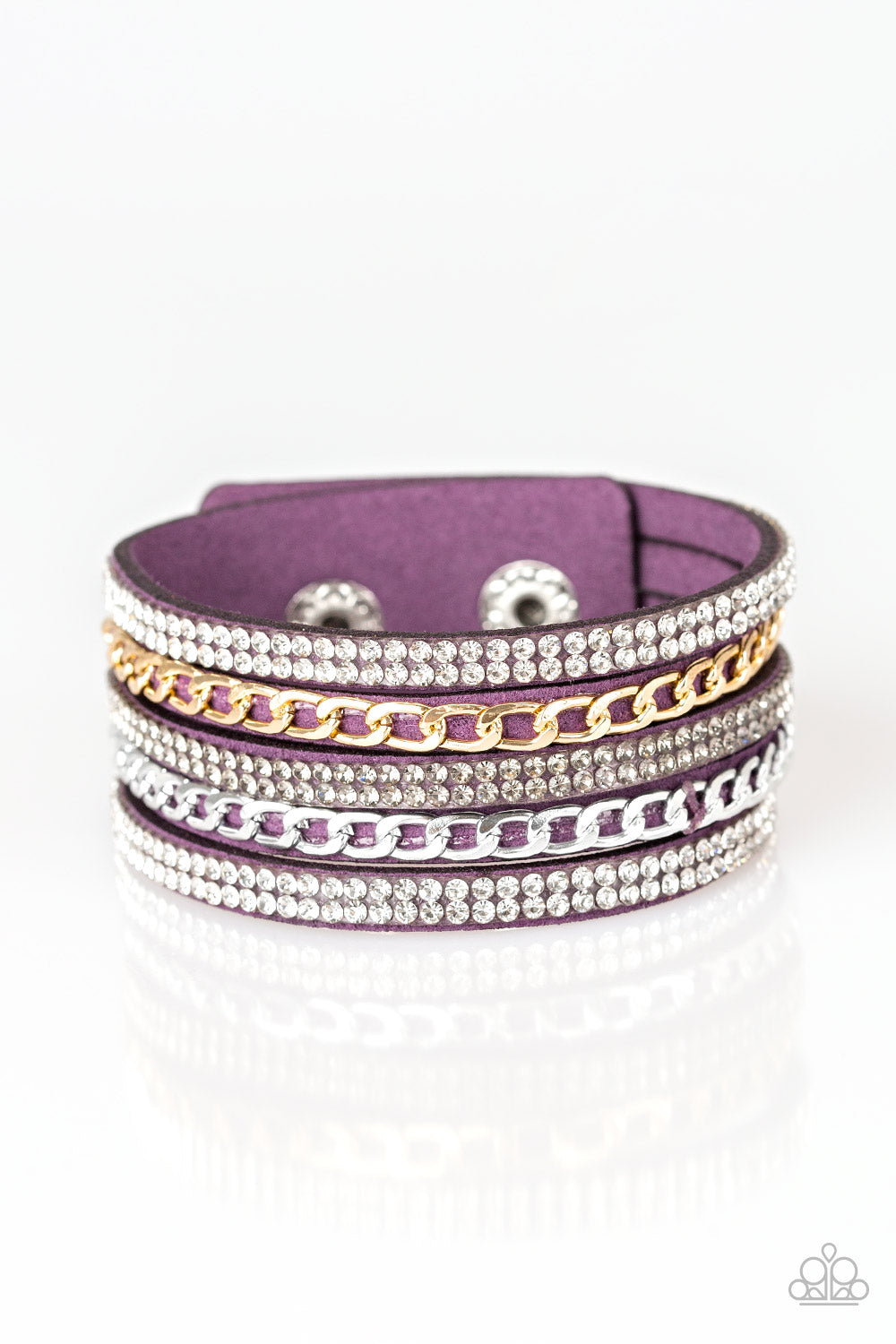Glassy white and smoky rhinestones are encrusted along strands of purple suede. Glistening silver and gold chains are added to the bands, adding edgy industrial shimmer to the sassy palette. Features an adjustable snap closure. Sold as one individual bracelet.