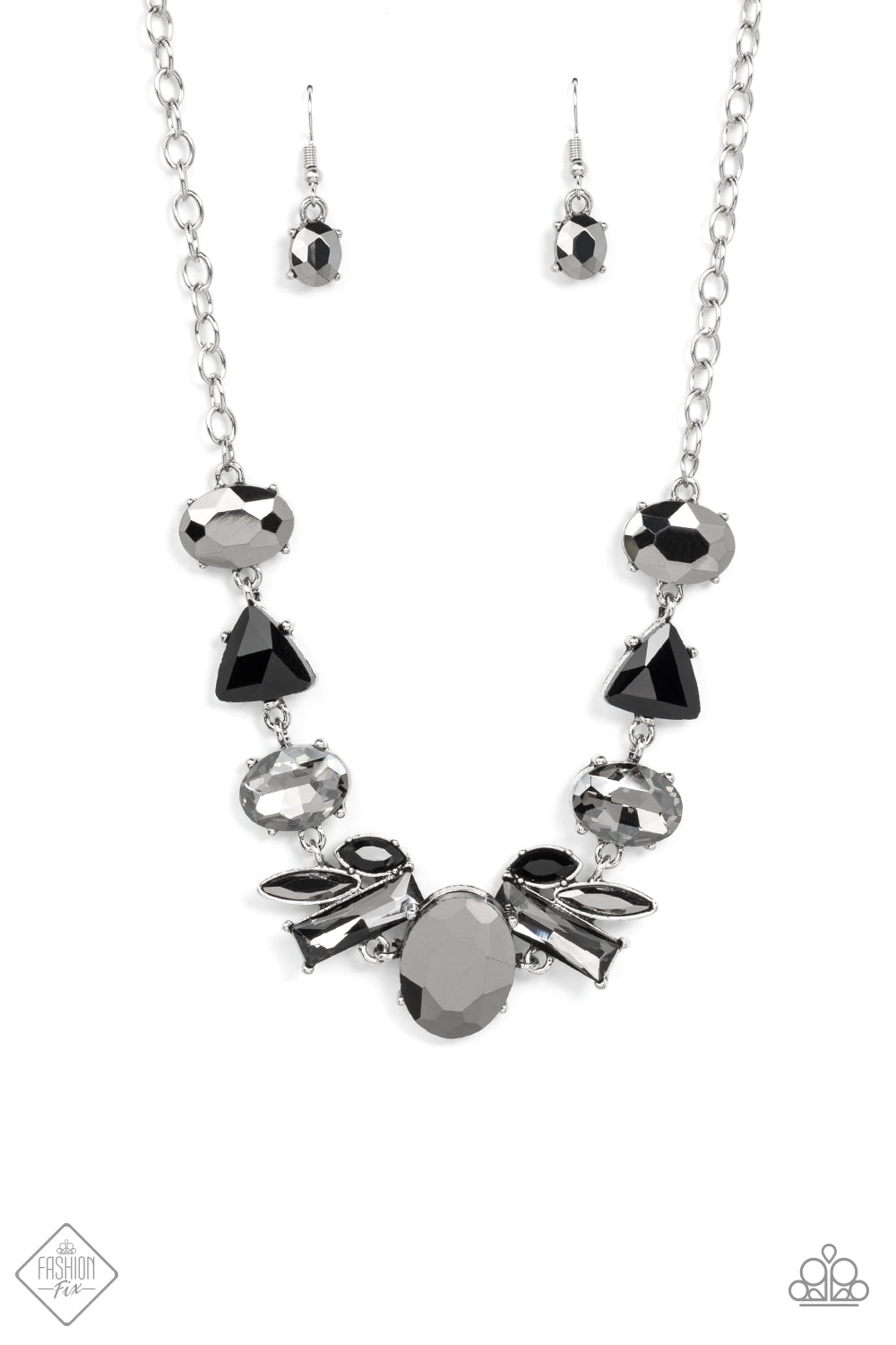 Anchored by a glassy oval hematite gem, a mismatched collection of lustrous hematite, smoky, and black rhinestones in various modern shapes and sizes link together across the collar. The gritty display gives way to a classic silver chain for a sleek finish. Features an adjustable clasp closure. Sold as one individual necklace. Includes one pair of matching earrings.