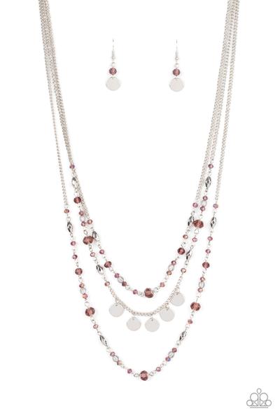 Varying in shape and shimmer, a glittery collection of faceted silver beads, sparkly purple crystal-like beads, and glassy beads adorn three dainty silver chains below the collar. Shimmery silver discs adorn the center of the centermost strand, adding flirtatious movement. Features an adjustable clasp closure. Sold as one individual necklace. Includes one pair of matching earrings.