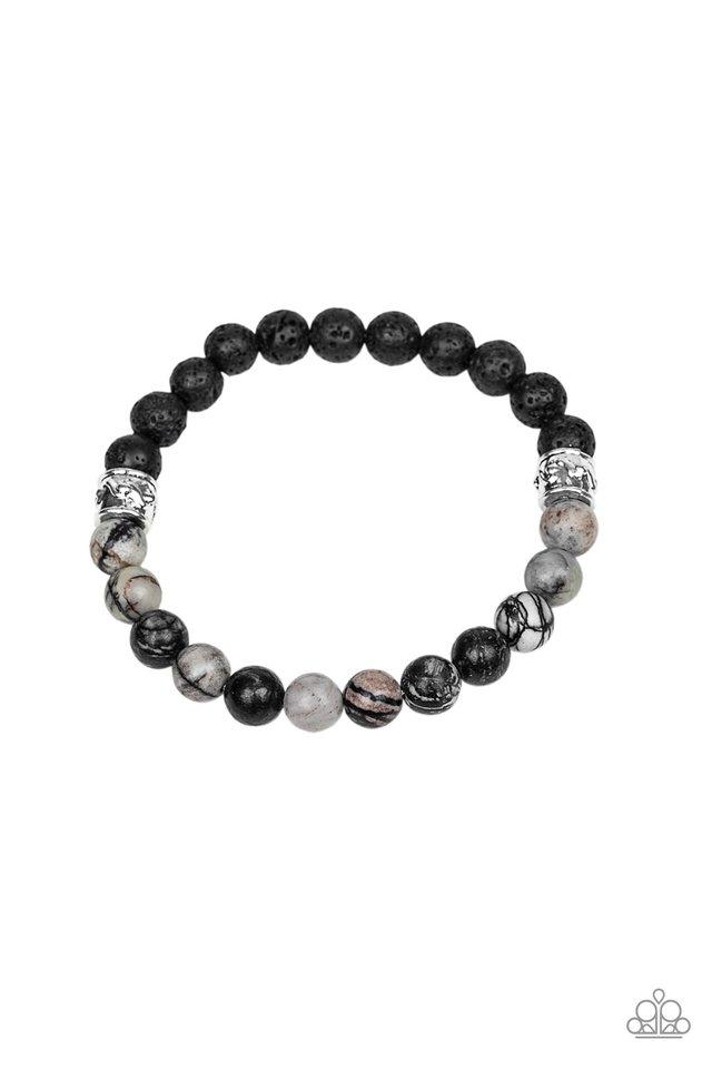 A collection black lava rock beads, smoky stone beads, and ornate silver accents are threaded along a stretchy band around the wrist for a seasonal look. Sold as one individual bracelet.