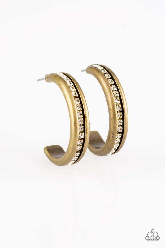 A row of glassy white rhinestones is encrusted down the spine of a burnished brass hoop for a refined look. Earring attaches to a standard post fitting. Hoop measures 1 1/4" in diameter.  Sold as one pair of hoop earrings.