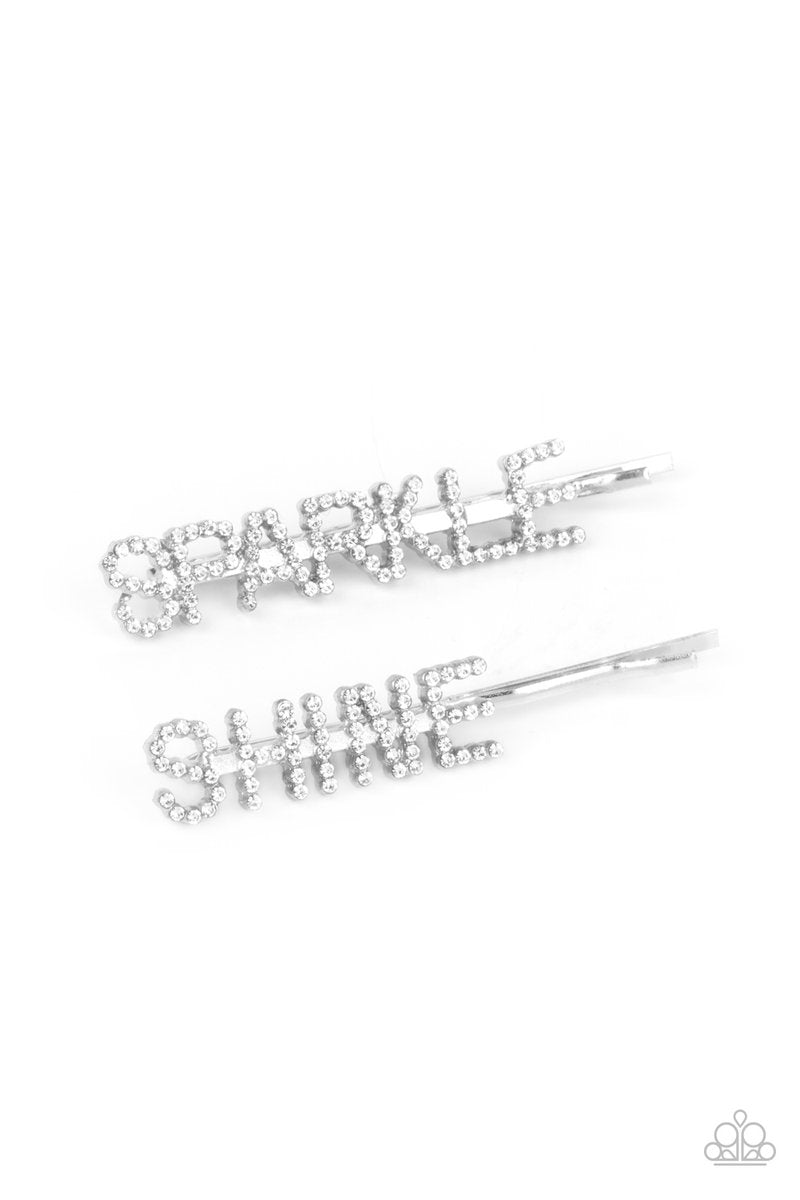 Glassy white rhinestones spell out "Sparkle," and "Shine," across the fronts of two silver bobby pins, creating a sparkly duo. Sold as one pair of decorative bobby pins.