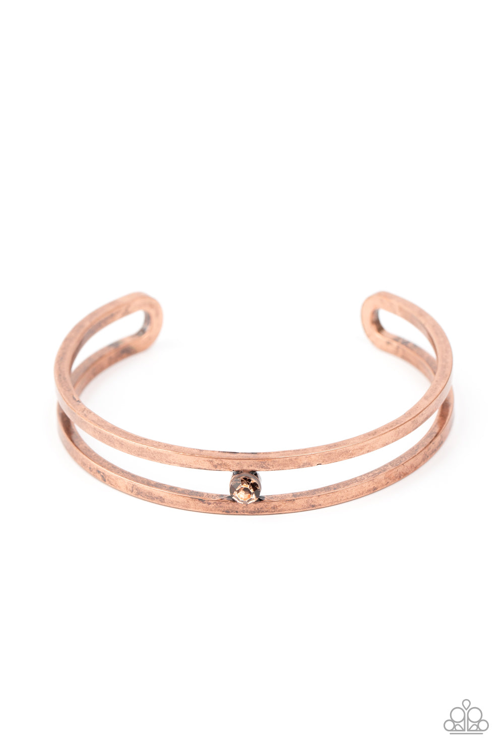 A dainty rhinestone is nestled inside the center of an airy copper cuff, adding a gritty pop of color to the wrist. Sold as one individual bracelet.