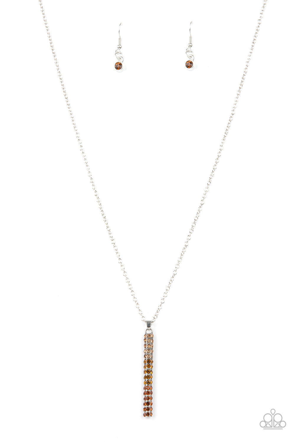 A sparkly collection of light, golden, and classic topaz rhinestones are encrusted along a silver pendulum that swings along the bottom of a silver chain, creating a glittery ombre effect. Features an adjustable clasp closure. Sold as one individual necklace. Includes one pair of matching earrings.