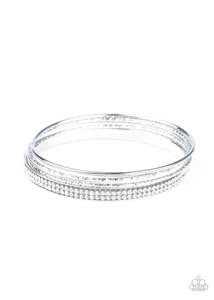 Pairs of smooth and hammered silver bangles join a white rhinestone encrusted bracelet around the wrist, creating an edgy stack of sparkle. Sold as one set of five bracelets.
