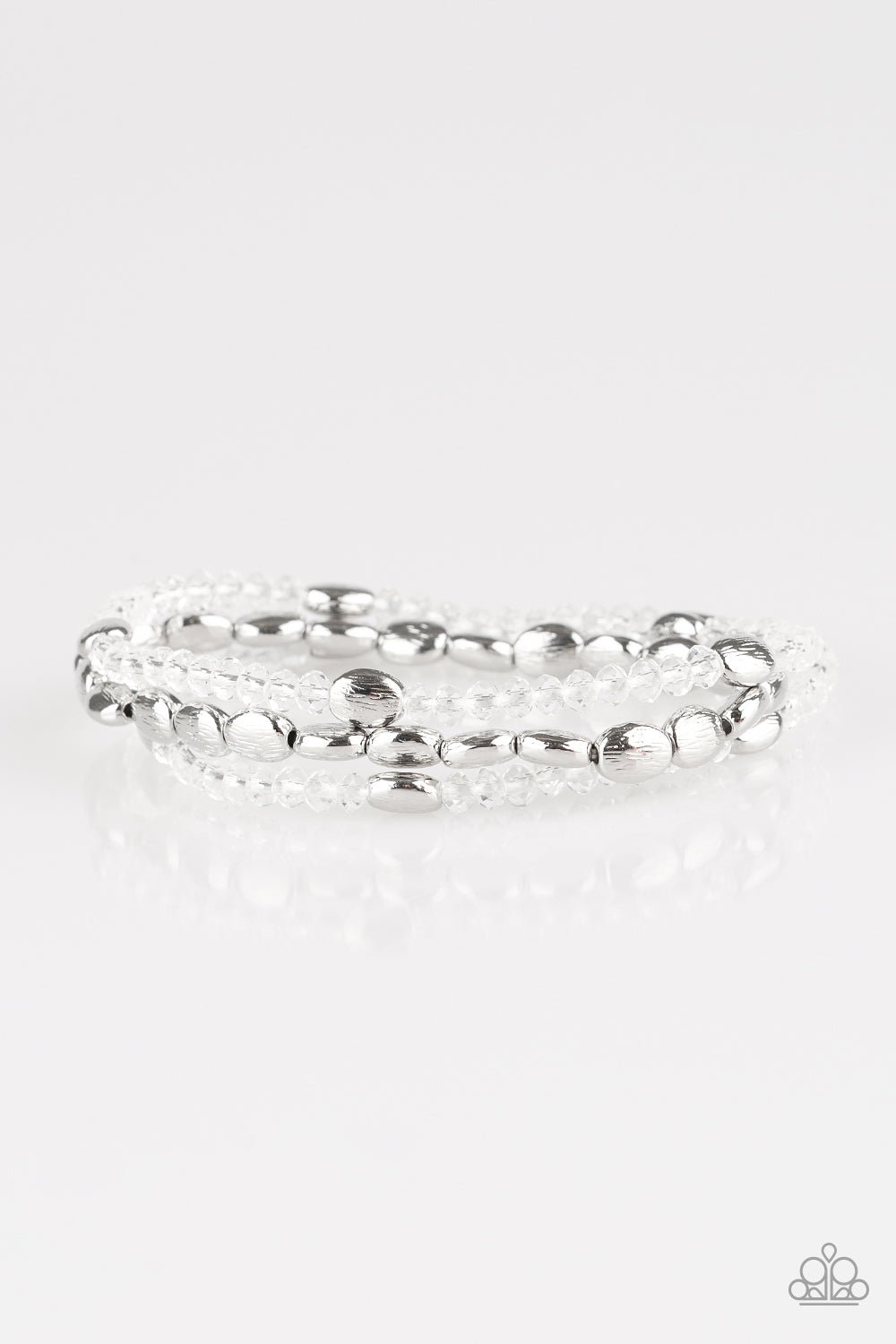Infused with hints of silver, dainty white crystal-like beads are threaded along stretchy bands, creating whimsical layers across the wrist.
Sold as one set of three bracelets.