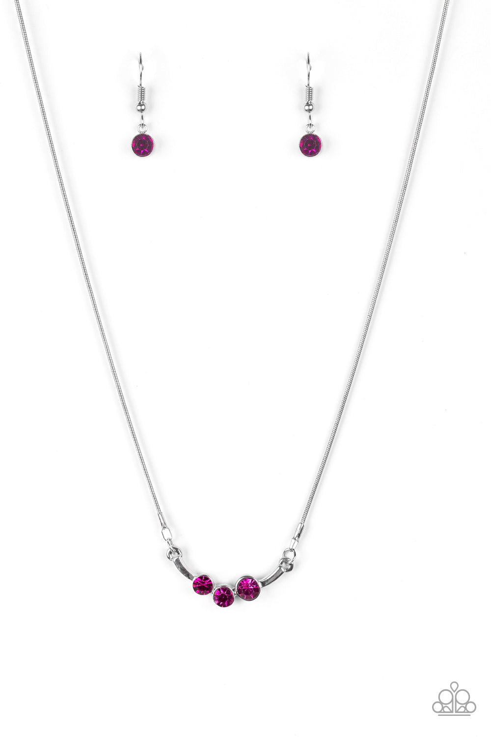 A trio of glittery pink rhinestones are encrusted along a bowing silver bar, creating a stellar pendant below the collar. Features an adjustable clasp closure. Sold as one individual necklace. Includes one pair of matching earrings.