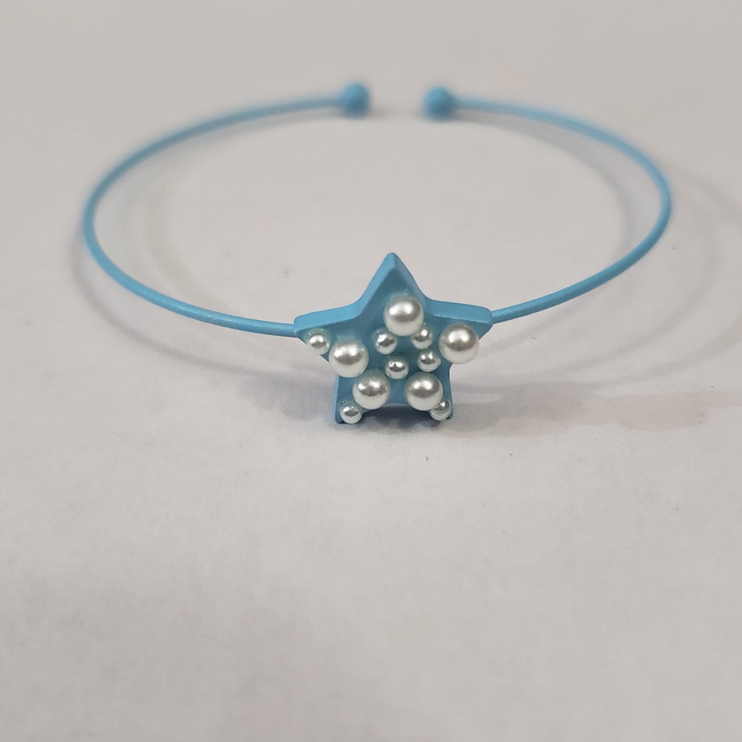 Pearl-dotted star accents, the dainty cuffs and pearls in blue setting. Sold as one Individual bracelet.