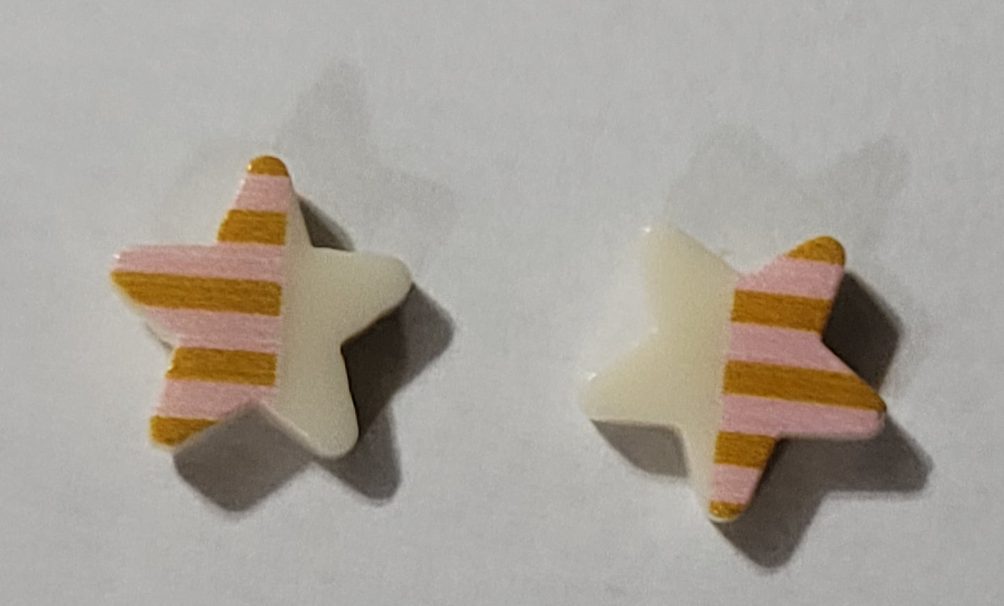 Kids' star shaped earrings with white on one side and peach with darker peach stripes on the other