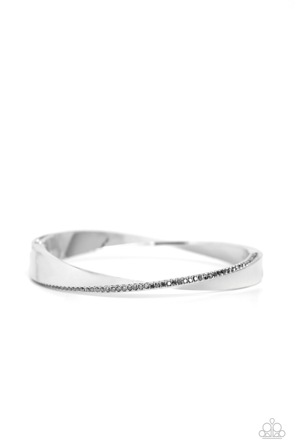 An oversized, warped, shiny silver cuff wraps around the wrist in an artistic manner. A dainty row of hematite rhinestones encrusts along the curves of the cuff for an understated, elegant dazzle. Features a hinged closure. Sold as one individual bracelet.