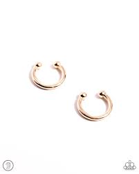 A small, skinny, gold hoop curves around the ear in a timeless fashion. Dainty gold balls are affixed to the ends of the hoop, reminiscent of a barbell fitting, creating an edgy, one-size-fits-all cuff.