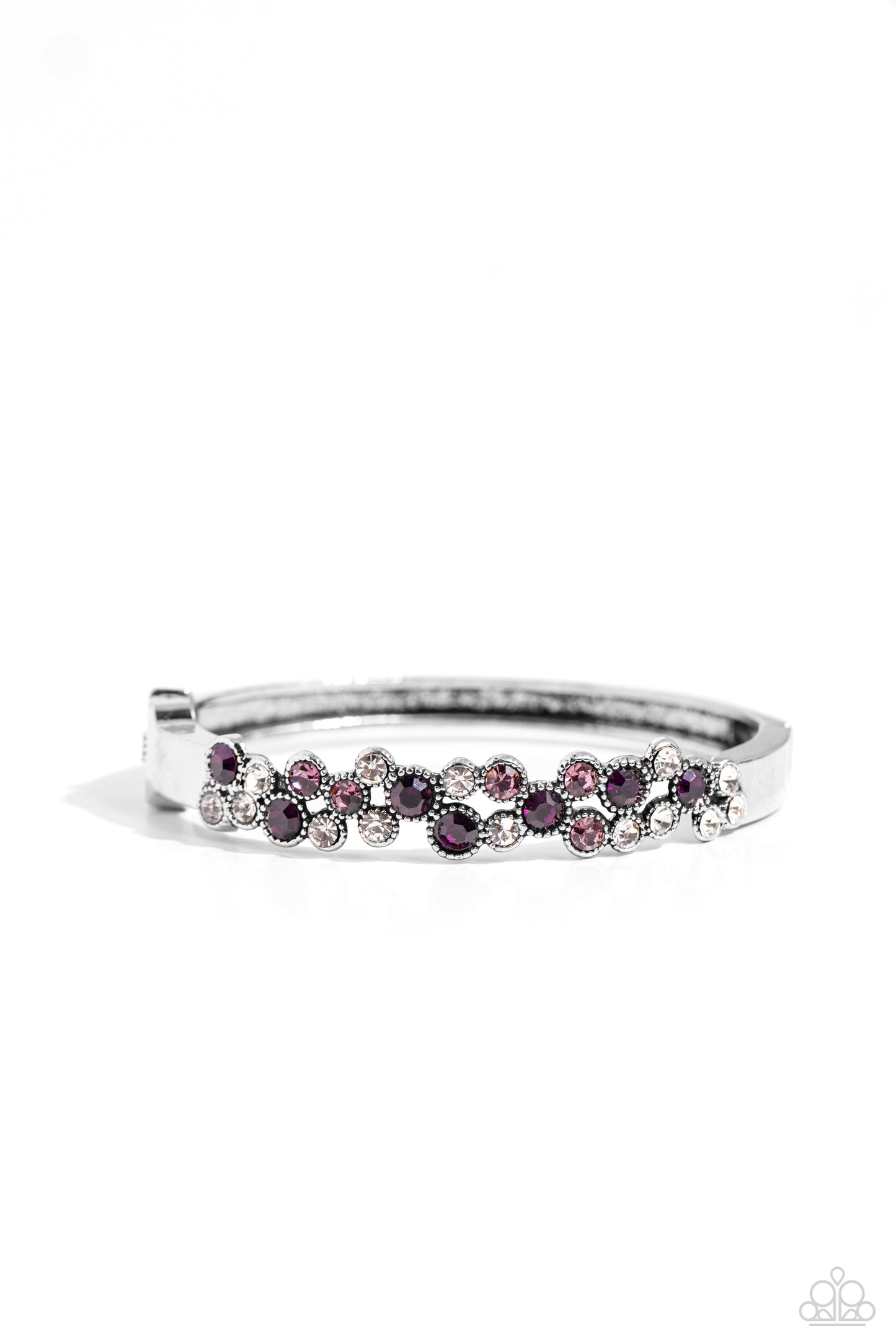 Featuring a crisscross pattern, a studded, framed collection of gems in varying sizes in shades of purple and white coalesce the top of a thick, silver bracelet for a pop of shimmery color atop the wrist. Features a hinged closure. Sold as one individual bracelet.