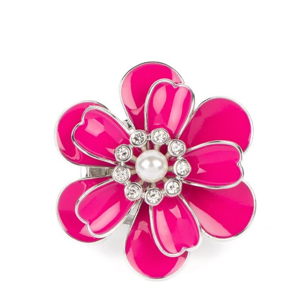 An exaggerated pink flower with layers of petals blooms atop the finger in a vibrant display. A white pearl encircled by tiny white rhinestones adds a touch of whimsical sparkle to the design. Features a stretchy band for a flexible fit. Sold as one individual ring.