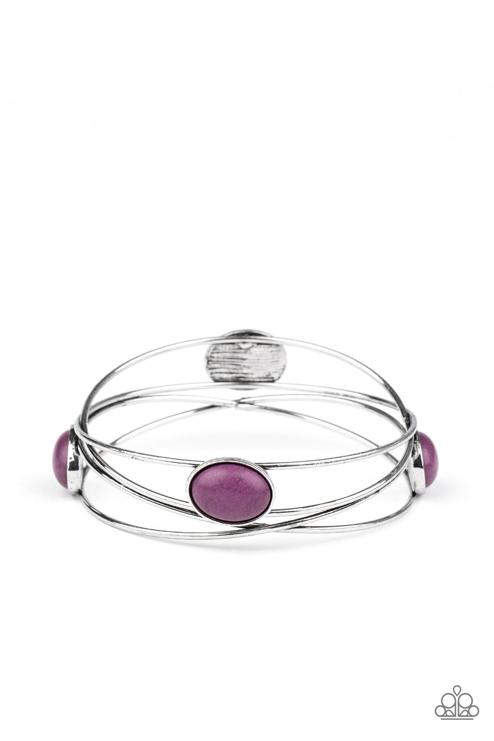 Dotted in oval purple stones, a stack of shimmery silver bangles haphazardly layer into a one-of-a-kind bracelet. Sold as one individual bracelet.