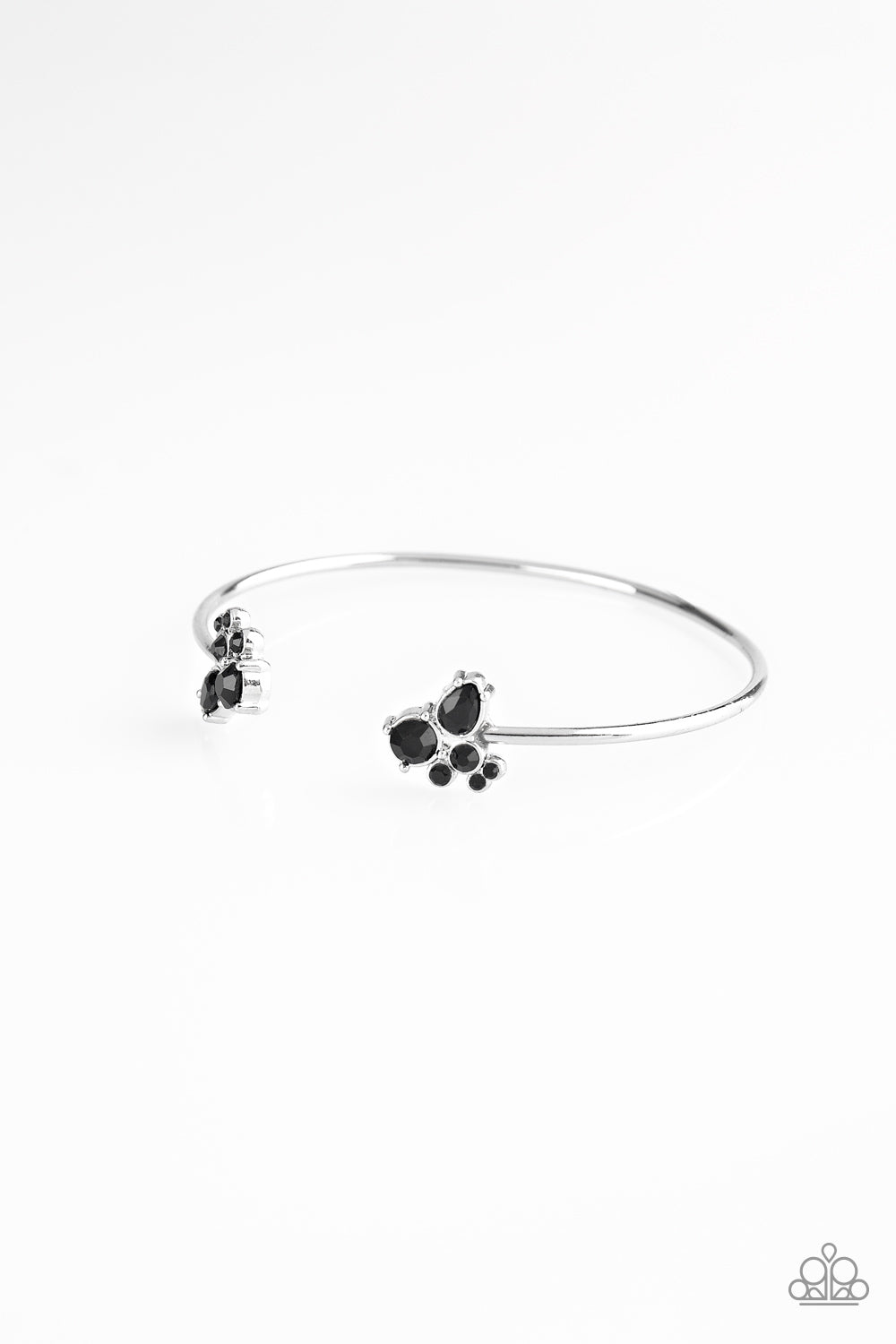 Varying in shape, glittery black rhinestones join at both ends of a dainty silver cuff, creating refined fittings. Sold as one individual bracelet.