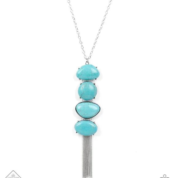 Stacked turquoise stones create an oversized pendant that sways from the bottom of a lengthened silver chain. The irregular-shaped stones add artisanal character while a flirty fringe of dainty chains adds playful energy. Features an adjustable clasp closure. Sold as one individual necklace. Includes one pair of matching earrings.