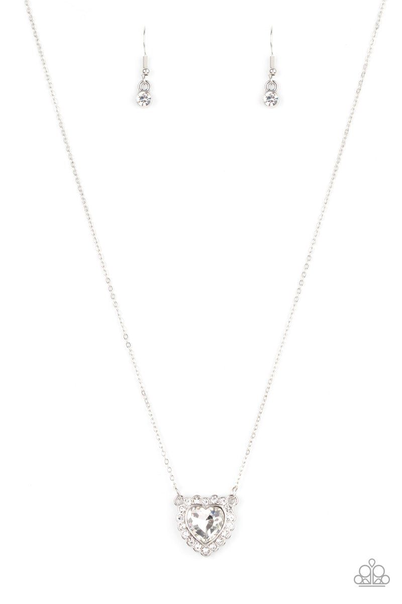 Glittery white rhinestones encircle a white heart shaped gem, creating a flirty pendant below the collar. Features an adjustable clasp closure. Sold as one individual necklace. Includes one pair of matching earrings.