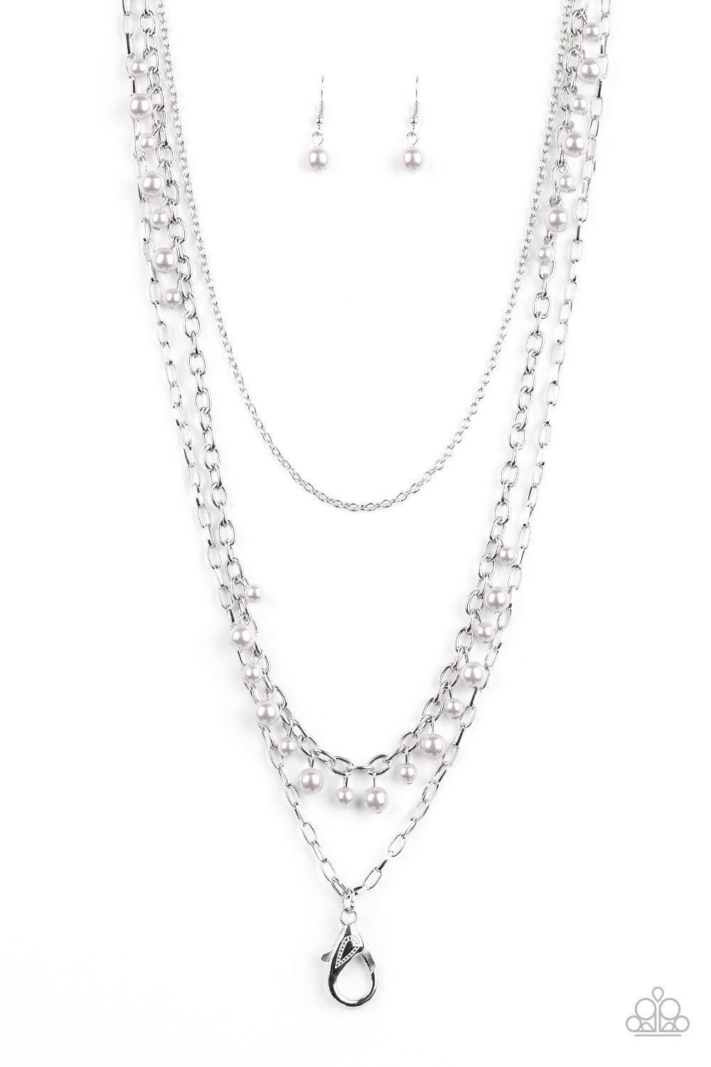 Three mismatched silver chains layer down the chest. Dainty silver pearls cascade down one silver chain, creating a refined fringe. A lobster clasp hangs from the bottom of the design to allow a name badge or other item to be attached. Features an adjustable clasp closure. Sold as one individual lanyard. Includes one pair of matching earrings.