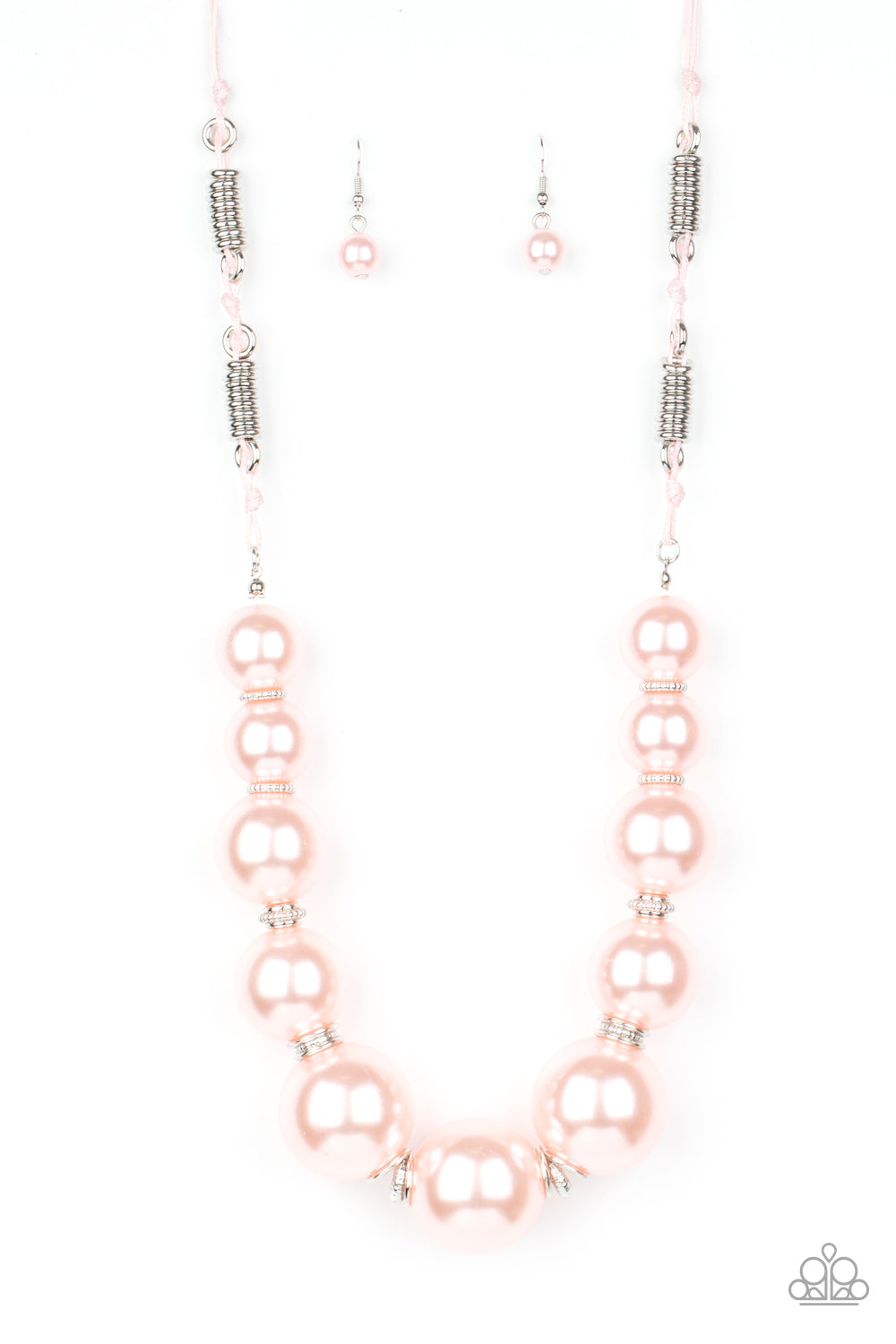 Separated by stacks of smooth and decorative silver rings, a collection of dramatically oversized pink pearls are delicately hand-strung along an invisible wire that attaches to knotted strands of pink cording for a classically handcrafted look. Features an adjustable clasp closure. Sold as one individual necklace. Includes one pair of matching earrings.