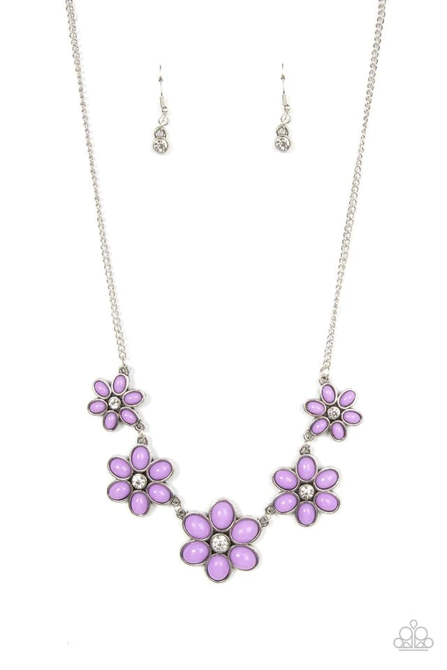 Dotted with dainty white rhinestone centers, a flirtatious assortment of purple beaded flowers gradually increase in size as they link below the collar for a playful pop of color. Features an adjustable clasp closure. Sold as one individual necklace. Includes one pair of matching earrings.