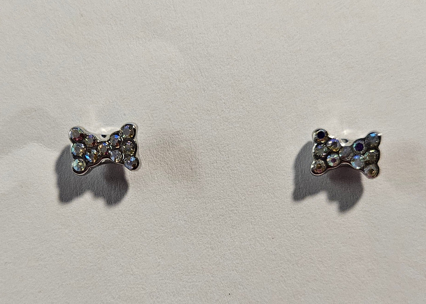 Kids' silver bow tie shaped earrings with white rhinestones