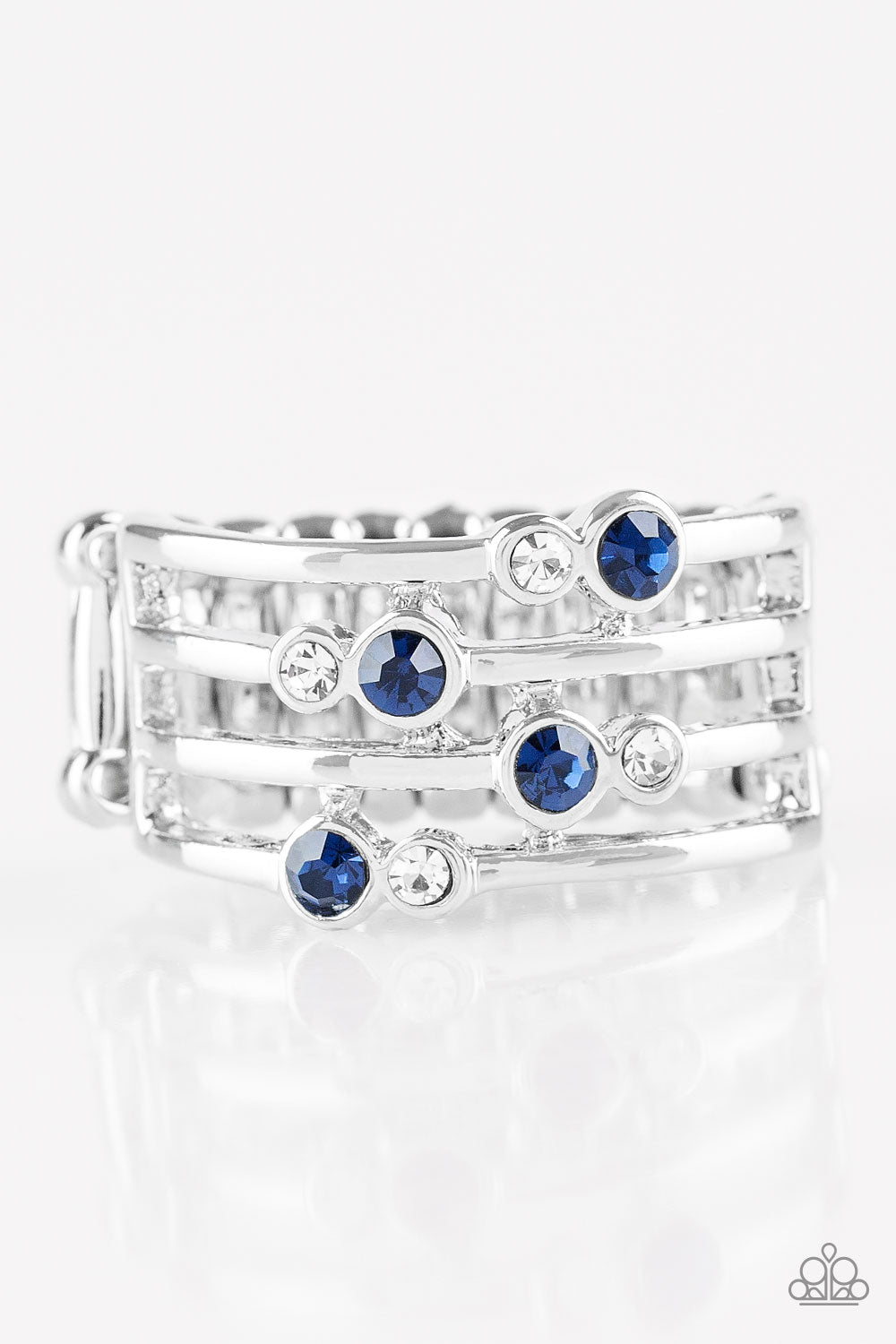Glittery blue and white rhinestones are scattered along arcing silver bands, coalescing into a refined frame. Features a stretchy band for a flexible fit. Sold as one individual ring.