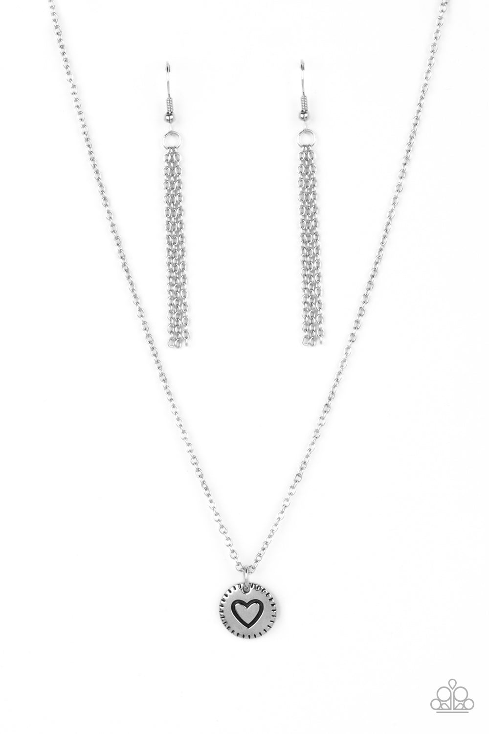 Stamped in a heart burst pattern, a round silver pendant is suspended from a dainty silver chain for a sentimentally sleek design. Features an adjustable clasp closure. Sold as one individual necklace. Includes one pair of silver fringe earrings.