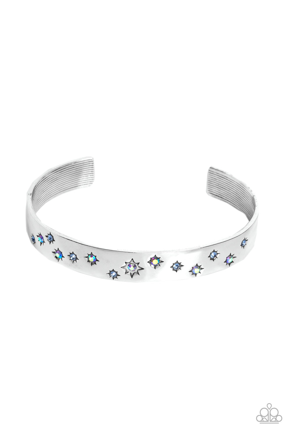 Tinted in subtle, stellar shades of blue and iridescence, dainty rhinestones are pressed into the centers of stamped stars in varying sizes. Embossed in tactile textures, the starry collection wraps around the wrist against a backdrop of a high-sheen silver cuff, emitting further glow to the design. Due to its prismatic palette, color may vary. Sold as one individual bracelet.