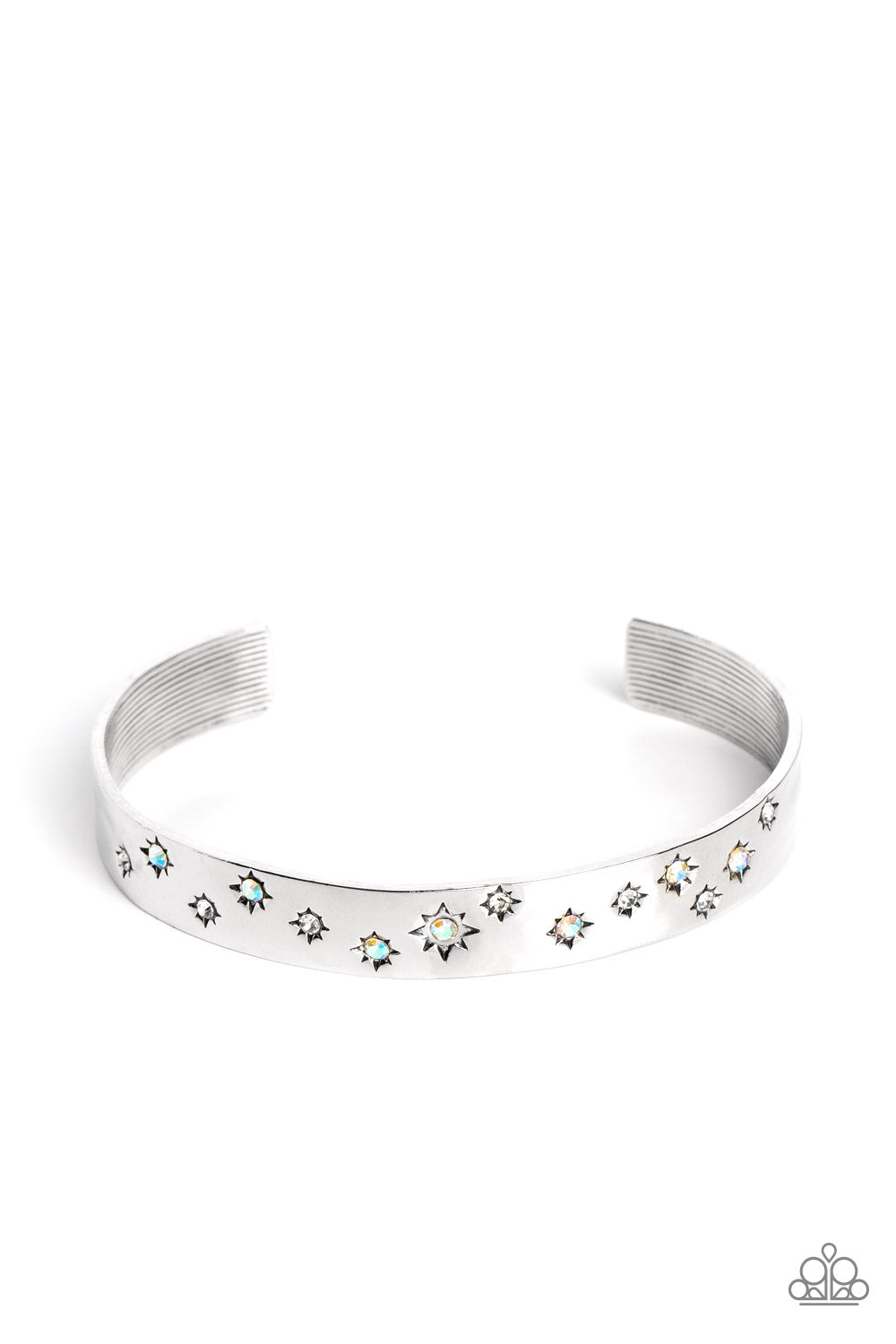 Tinted in subtle, stellar shades of white and iridescence, dainty rhinestones are pressed into the centers of stamped stars in varying sizes. Embossed in tactile textures, the starry collection wraps around the wrist against a backdrop of a high-sheen silver cuff, emitting further glow to the design. Due to its prismatic palette, color may vary. Sold as one individual bracelet.