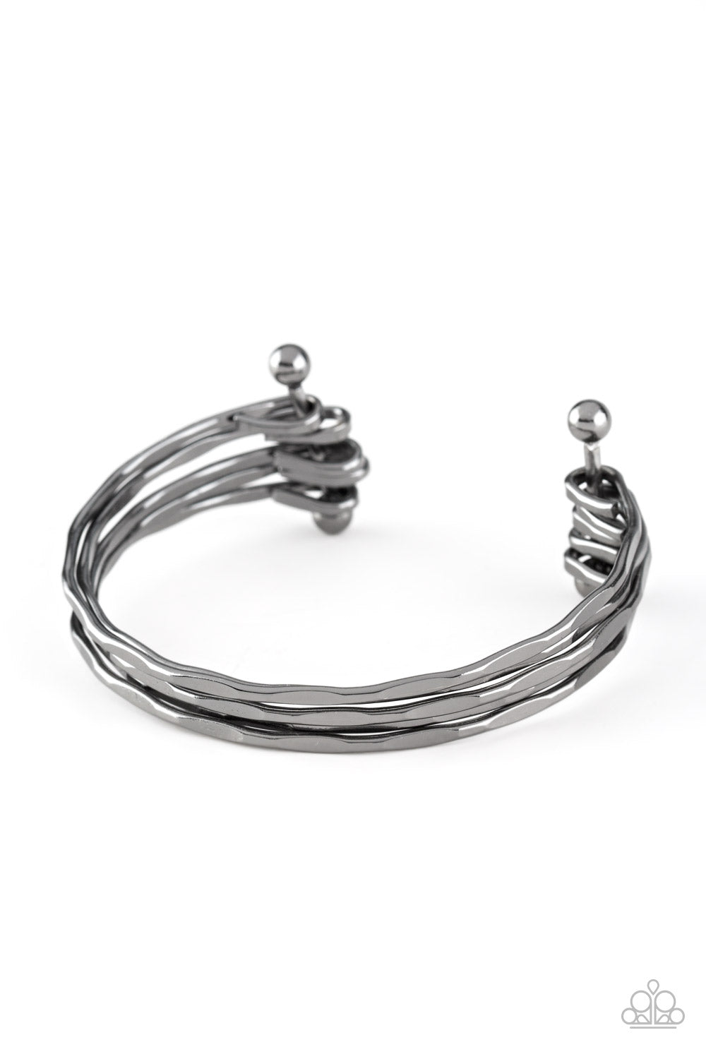 Delicately hammered in sections of shimmer, glistening gunmetal bars are threaded along two metallic rods, creating a layered cuff across the wrist. Sold as one individual bracelet.