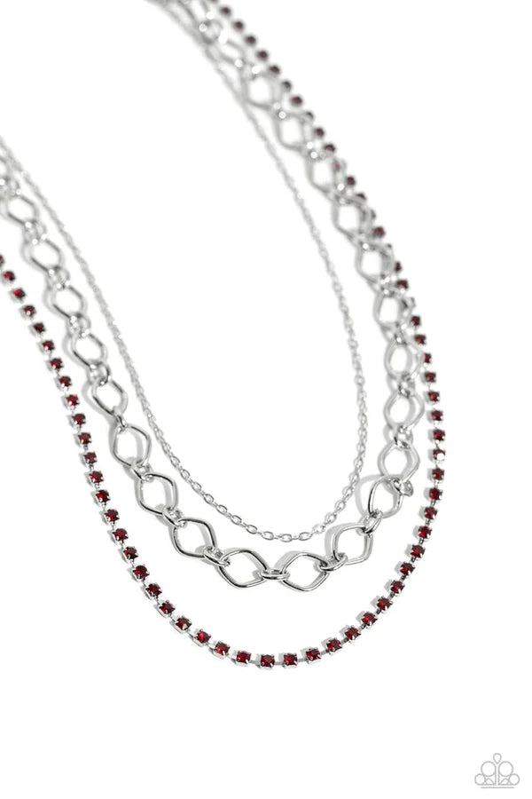 A dainty strand of red rhinestones, set in silver square fittings, joins a dainty silver strand of silver chain and a silver oval link chain below the collar, creating refined layers. Features an adjustable clasp closure. Sold as one individual necklace. Includes one pair of matching earrings.