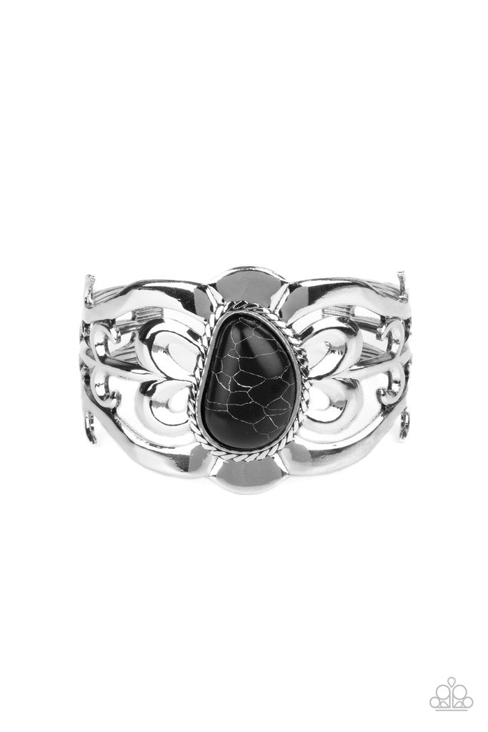 An asymmetrical black stone is pressed into the center of a silver cuff layered with filigree patterns around the wrist for a rustic flair. Sold as one individual bracelet.