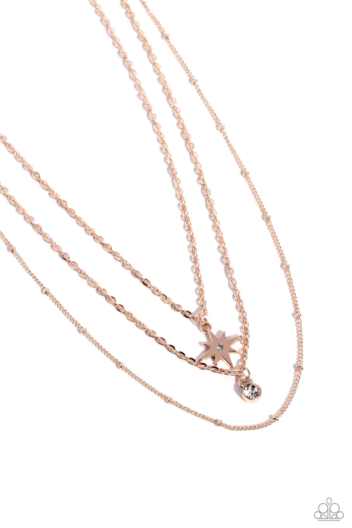 Three dainty rose gold chains layer across the chest, creating a tiered display of high sheen texture. A rose gold star topped with a small rhinestone swings from the upper most chain, while a solitaire rhinestone slides along the middle strand. The delicate design is topped off by the satellite chain, which adds a hint of texture. Features an adjustable clasp closure. Sold as one individual necklace. Includes one pair of matching earrings.