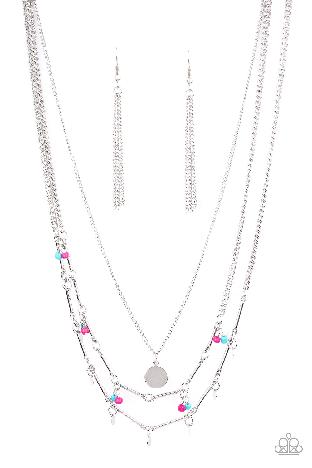A silver disc is suspended above two mismatched silver chains featuring a mismatched array of silver bars, silver discs, and pairs of blue and pink seed beads. The dainty display delicately layers below the collar, creating a colorful fringe. Features an adjustable clasp closure. Sold as one individual necklace. Includes one pair of silver fringe earrings.