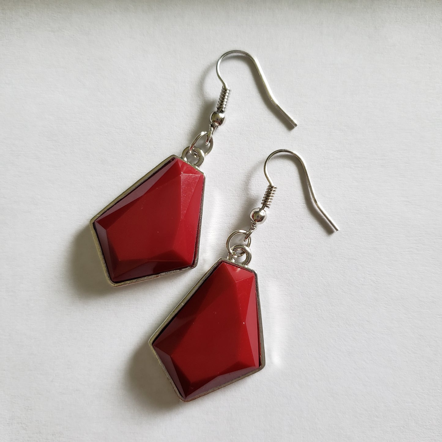Featuring emerald-style cuts, faceted red beads are pressed into sleek silver frames. The colorful frames join at the bottom of a shimmery silver chain, creating a bold geometric fringe below the collar. Features an adjustable clasp closure. Sold as one individual necklace. Includes one pair of matching earrings.