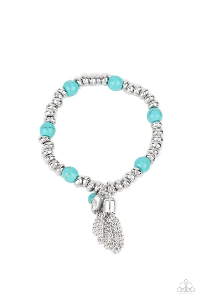 An earthy collection of hammered silver beads and round turquoise stones are threaded along a stretchy band around the wrist. A dainty silver tassel, hammered silver disc, and a turquoise stone swing from the seasonal display, adding playful movement to the whimsy look. Sold as one individual bracelet.