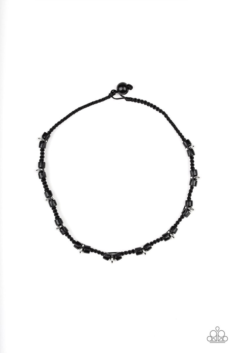 Braided cording knots around black wooden and shiny silver beads below the collar for an urban look. Features a button loop closure. Sold as one individual necklace.
