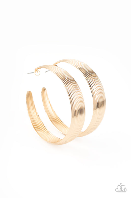 Lined in glistening ridges, a thick gold hoop curls around the ear for an authentically rustic look. Earring attaches to a standard post fitting. Hoop measures approximately 2 ¼” in diameter.  Sold as one pair of hoop earrings.