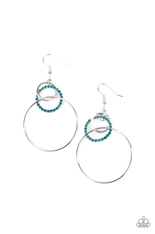 Varying in size, a glittery blue rhinestone encrusted ring links with two shiny silver hoops, creating a glamorous lure. Earring attaches to a standard fishhook fitting.

Sold as one pair of earrings.