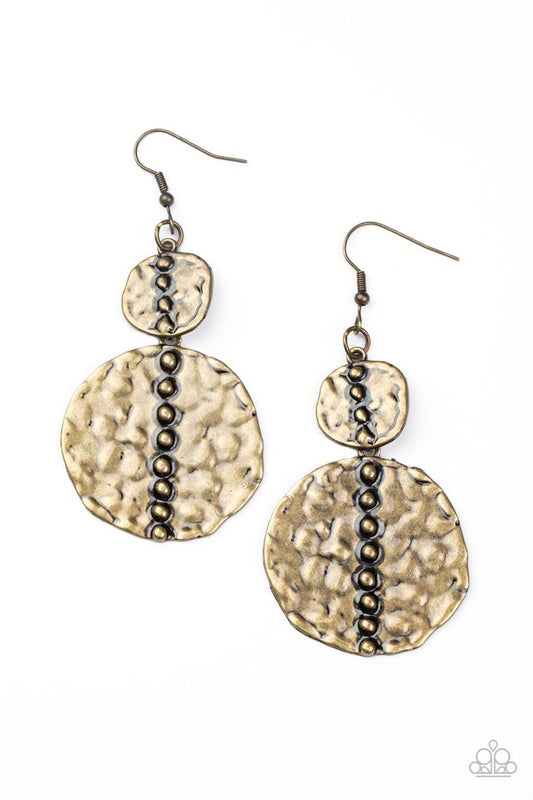 Embossed in tactile textures, a studded pair of asymmetrical brass discs connect into a rustic lure. Earring attaches to a standard fishhook fitting.  Sold as one pair of earrings.