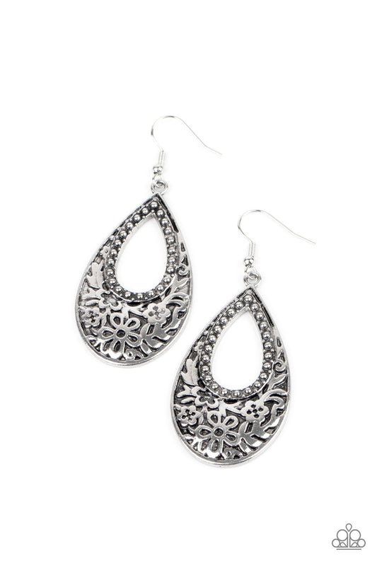 Featuring an airy studded center, the thickened bottom of an antiqued silver teardrop is embossed in a flowery pattern for a whimsical flair. Earring attaches to a standard fishhook fitting.  Sold as one pair of earrings.