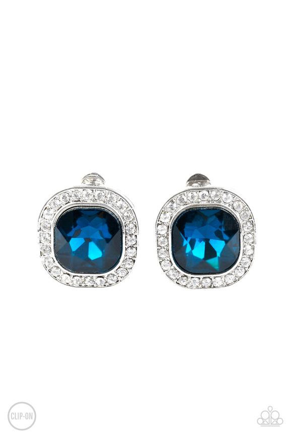 A regal blue gem is pressed into the center of a shimmery silver frame radiating with glassy white rhinestones for a glamorous look. Earring attaches to a standard clip-on fitting.  Sold as one pair of clip-on earrings.