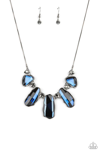 A glittery collection of raw cut blue gems delicately link with dainty hematite rhinestone dotted gunmetal teardrops below the collar, creating a stellar fringe. Features an adjustable clasp closure.  Sold as one individual necklace. Includes one pair of matching earrings.