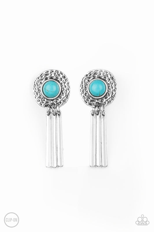 Dotted with a refreshing turquoise stone center, a hammered silver frame gives way to a fringe of shiny silver bars for a seasonal flair. Earring attaches to a standard clip-on fitting.  Sold as one pair of clip-on earrings.