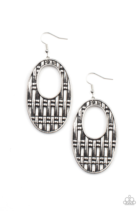 Oversized antiqued silver oval cut-out frames are embossed with a bold basket weave design resulting in a dramatic statement making finish. Earring attaches to a standard fishhook fitting.  Sold as one pair of earrings.