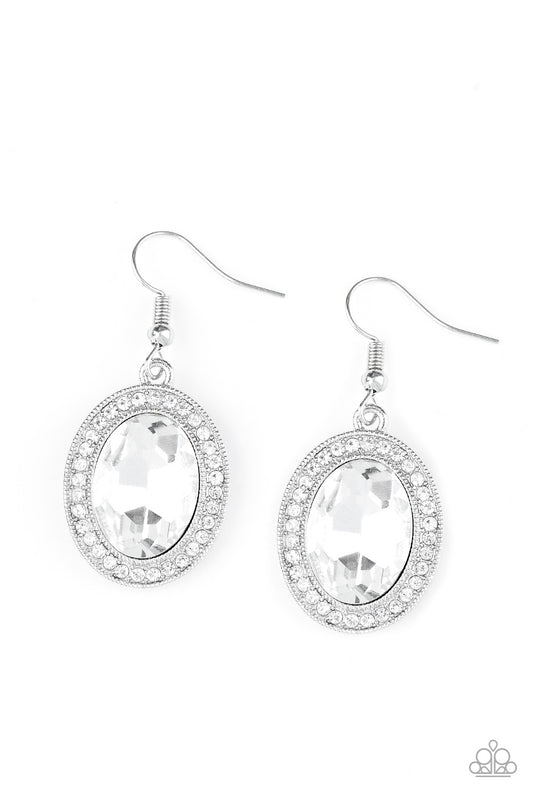 An oversized white gem is pressed into the center of a silver frame radiating with glassy white rhinestones for a glamorous look. Earring attaches to a standard fishhook fitting.  Sold as one pair of earrings.