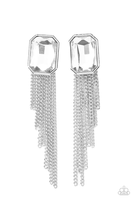 Tapered silver chains stream from the bottom of an oversized white emerald cut gem, creating a regal fringe. Earring attaches to a standard post fitting.  Sold as one pair of post earrings.