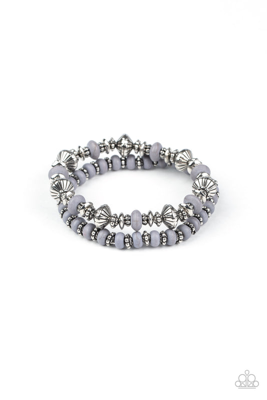 A mismatched assortment of Sleet stone beads and decorative silver beads are threaded along stretchy bands around the wrist, creating an earthy pair.

Sold as one set two of bracelets.